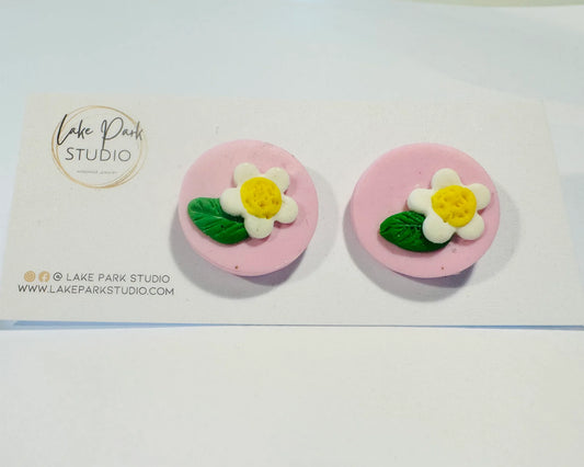 Lyserød ørestikkere med blomst